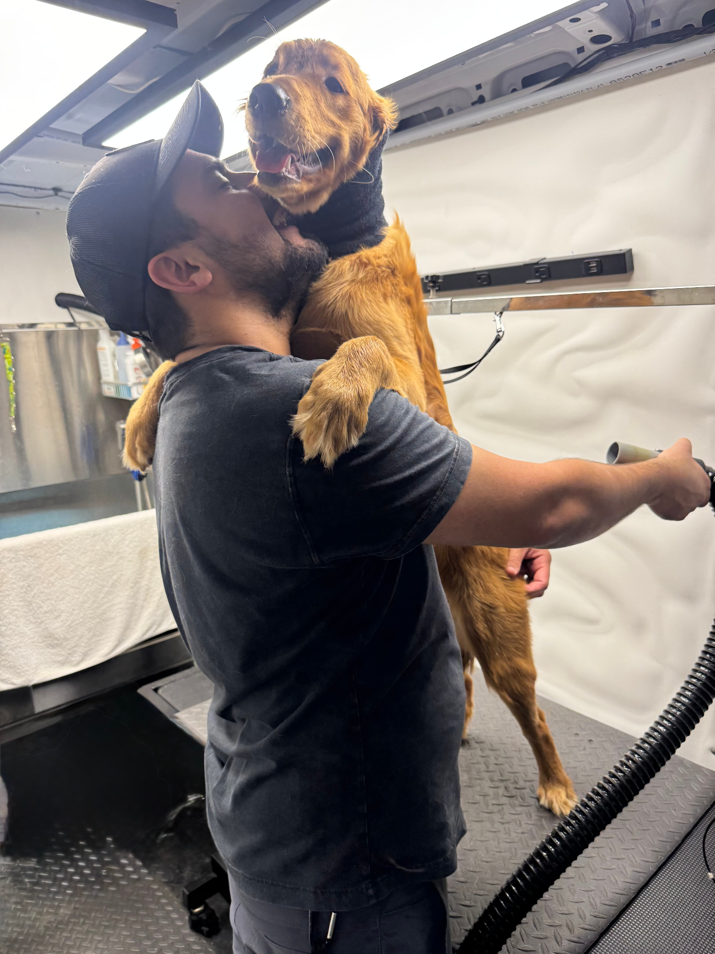 Victor sharing a loving moment with a Golden Retriever inside the Pawsionate mobile grooming van — Rockwall TX